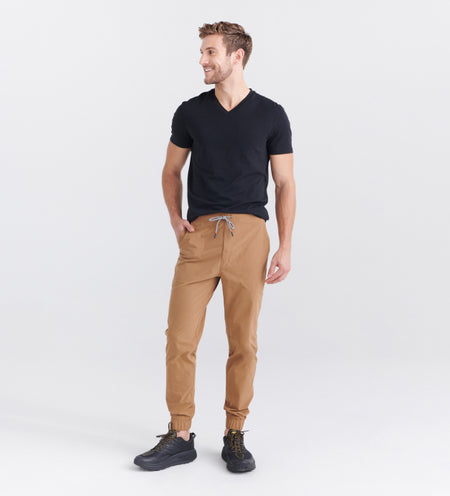 Man wearing beige joggers and black V neck
